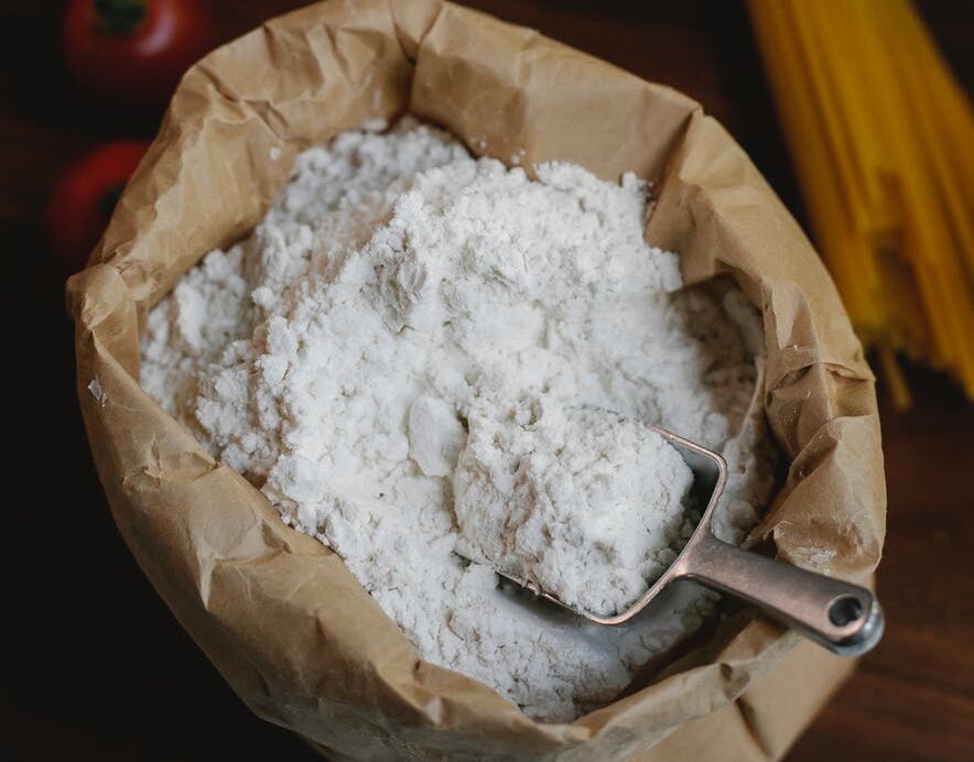 table with utensil and spaghetti near flour